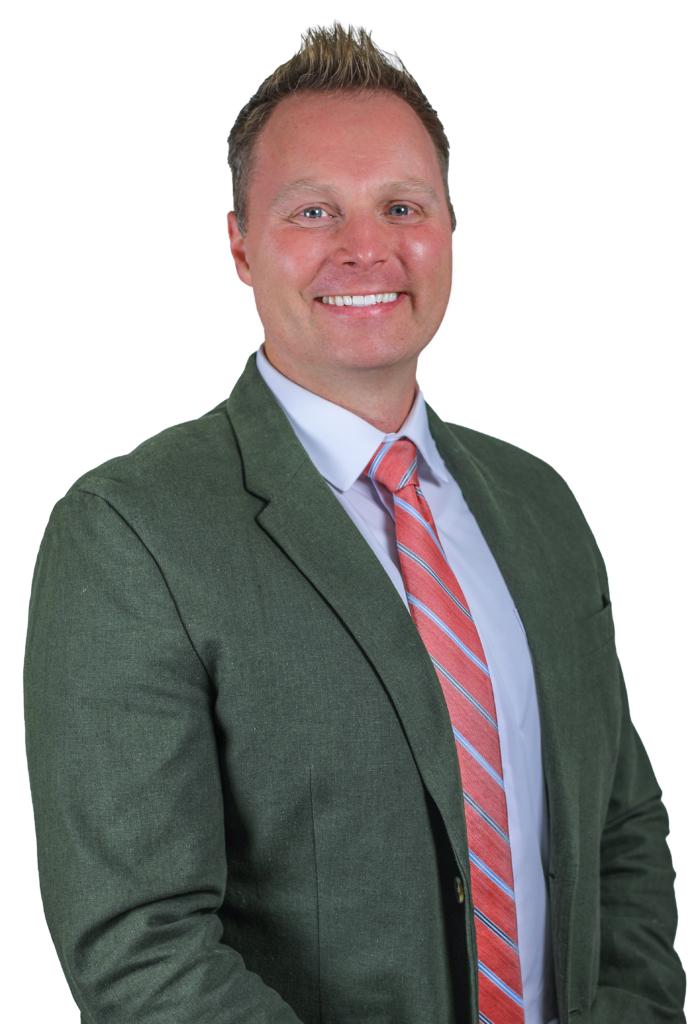 Smiling man in a green blazer and pink striped tie, posing for a professional headshot.